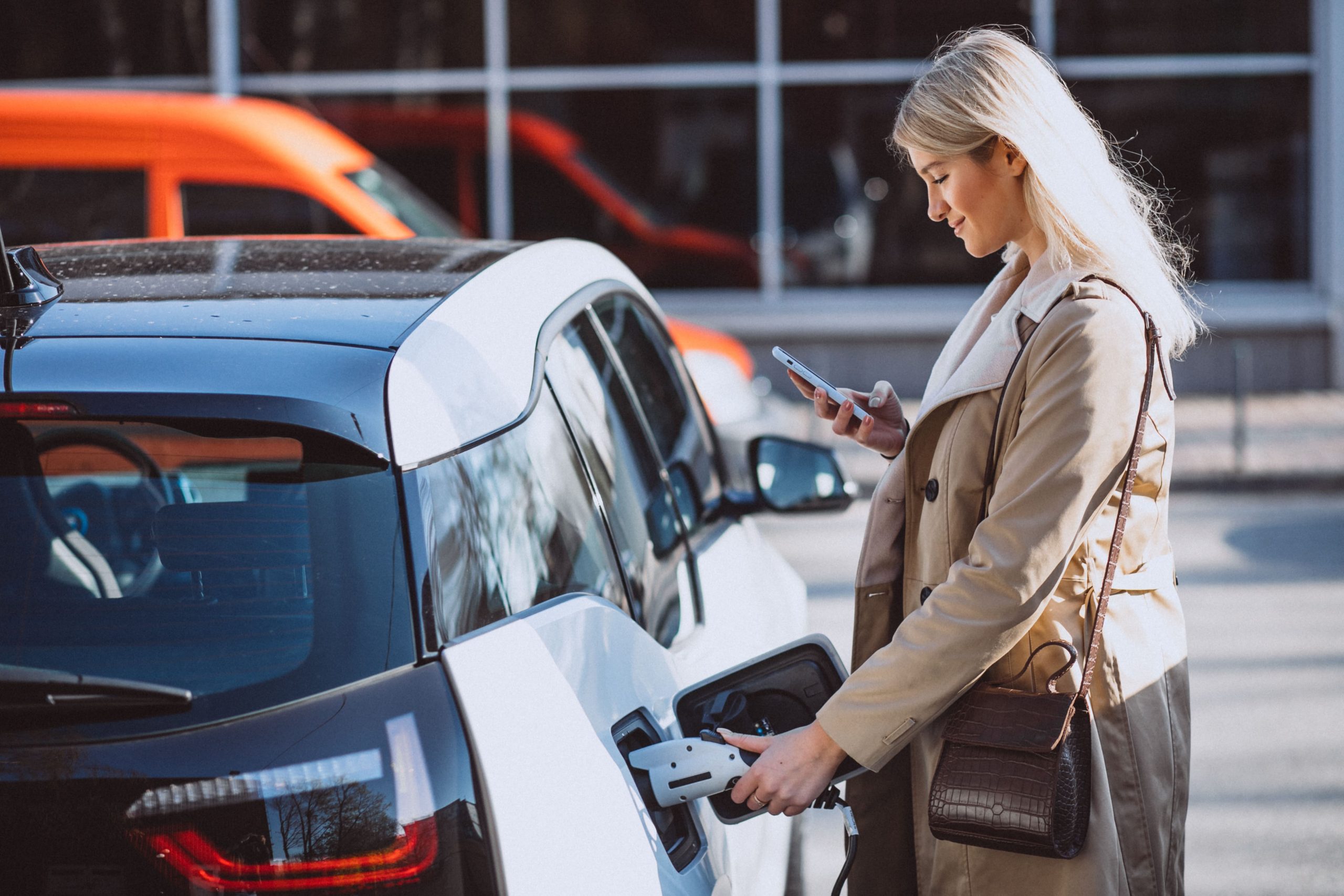 Mujer usando un cargador de vehículos eléctricos de la empresa.